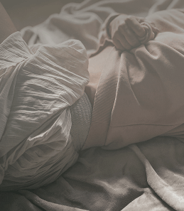 Close-up of a person lying down wearing protective absorbent underwear, representing the management of incontinence or bladder weakness